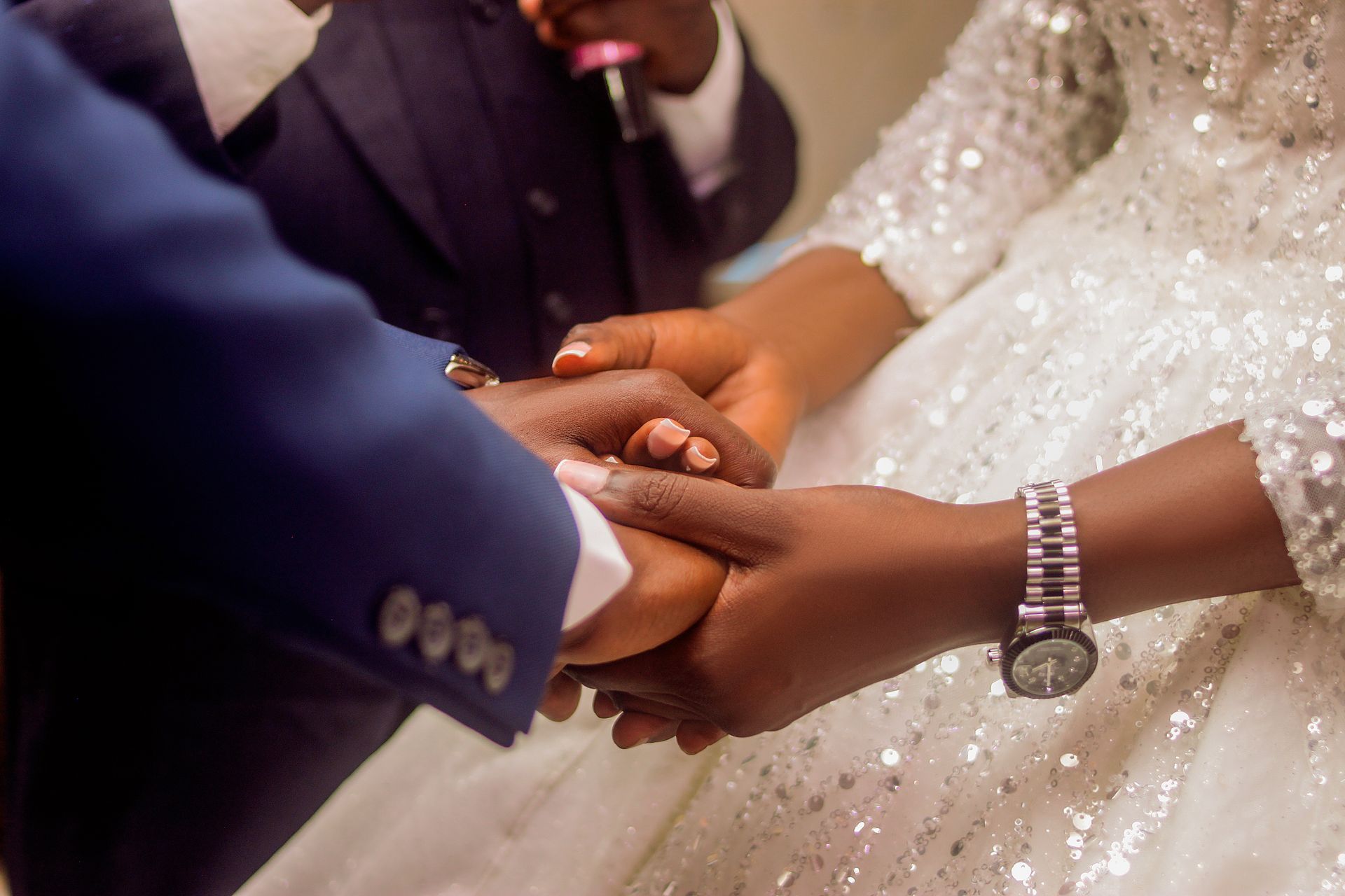 A bride and groom holding hands during a Nigerian wedding ceremony