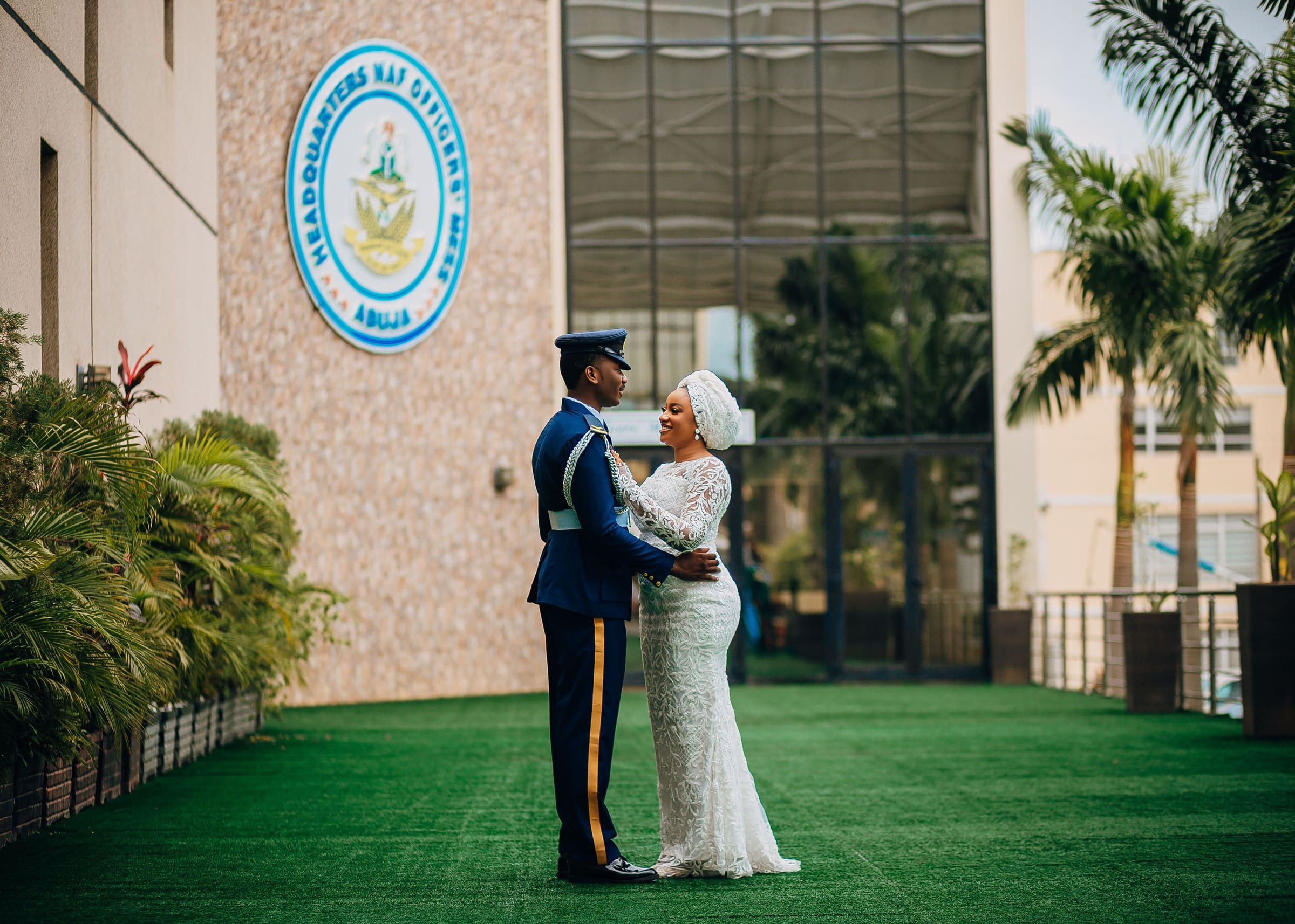 A Nigerian couple embracing in wedding attire outside a venue in Abuja