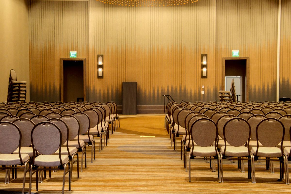 Rows of chairs set out either side of a central aisle in a conference hall