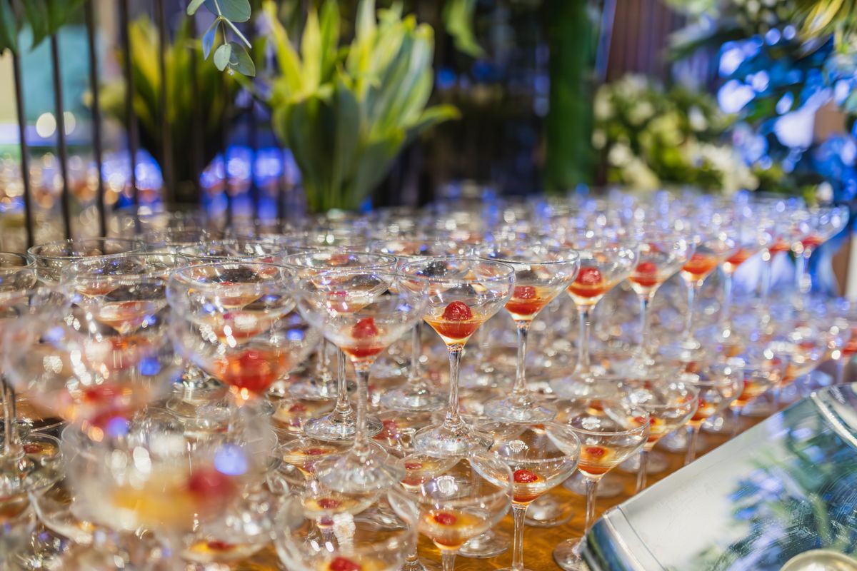 Rows of filled glasses set out on a table ready to be served